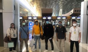 Para petugas imigrasi mengawal pendeportasian dua WNA (ditengah) yang overstay, di Bandara Ngurah Rai, Bali Sabtu (25/09/2021). ANTARA/HO-Kemenkumham Bali