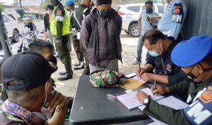Seorang warga terjaring razia karena mengenakan atribut militer celana panjang loreng