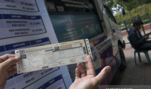 Warga menunjukkan STNK yang baru diperpanjang di Samsat Keliling, Jakarta, Selasa (3/1/2019). ANTARA FOTO/Rosa Panggabean/foc.