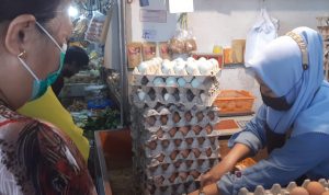 BERJUALAN: Pedagang telur tengah melayani pembeli.