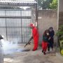 Petugas kesehatan melakukan fogging di lingkungan rumah warga.