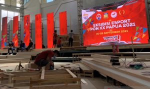 Sejumlah pekerja mempersiapkan panggung arena pertandingan cabang olahraga eksibisi esport PON XX Papua di lapangan Hoki dan Kriket di Doyo Baru, Jayapura, Minggu (19/9/2021). (ANTARA/Arindra Meodia)