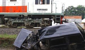 Dokumentasi. Sebuah kereta api melintas di depan bangkai mobil minibus bernopol N 1447 CP yang ringsek usai ditabrak kereta api di perlintasan tanpa palang pintu di Sonotengah, Malang, Jawa Timur, Rabu (27/10/2021). . ANTARA FOTO/Ari Bowo Sucipto/foc.