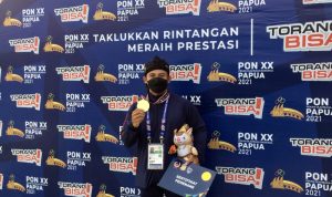 Atlet asal Jawa Barat Krisna Septiana menunjukkan medali emas setelah finis tercepat pada cabang olahraga dayung nomor slalom atau adu cepat dayung dengan rintangan di Pekan Olahraga Nasional (PON) Papua 2021 di Teluk Youtefa, Jayapura, Minggu (3/10/2021). (ANTARA/Shofi Ayudiana)