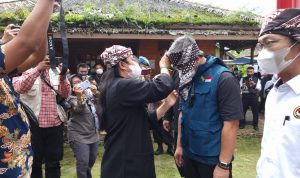 Abah Ande menyematkan ikat kepala kepada Kadis DPMD Jabar H Dicky Saromi pada acara vaksinasi massal di Kampung Adat Ciptarasa Kabupaten Sukabumi.