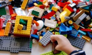 Seorang anak membuat rumah-rumahan yang disusun dari bongkahan Lego di Roma, Italia, Oktober 2020.