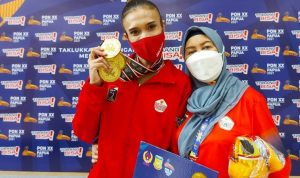 Nabila Evandestiera (kiri) yang menyumbangkan tiga medali emas untuk DKI Jakarta dari senam ritmik bersama dengan pelatihnya Negaka Jauhari di Istora Papua Bangkit, Jayapura, Jumat (8/10/2021). (ANTARA/Livia Kristianti)