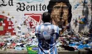 Kenang Maradona, Barcelona Gelar Pertandingan Hadapi Boca Juniors Seorang pria memandangi gambar legenda sepak bola Diego Armando Maradona sambil berduka atas kematiannya di depan stadion yang mengambil namanya di Buenos Aires, Argentina, Jumat (27/11/2020). ANTARA FOTO/REUTERS/Ricardo Moraes/HP/djo (REUTERS/RICARDO MORAES)