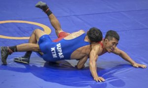 Pegulat putra Jatim Hasan Sidik (kanan) berusaha mengunci pegulat putra Kalimantan Timur Suparmanto (kiri) saat bertanding pada final gulat gaya greco-roman kelas 60 Kg PON Papua di Gor Futsal Dispora, Kabupaten Merauke, Papua, Rabu (13/10/2021). Hasan Sidik menang dan berhasil meraih medali emas. ANTARA FOTO/Galih Pradipta/YU