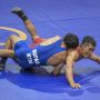 Pegulat putra Jatim Hasan Sidik (kanan) berusaha mengunci pegulat putra Kalimantan Timur Suparmanto (kiri) saat bertanding pada final gulat gaya greco-roman kelas 60 Kg PON Papua di Gor Futsal Dispora, Kabupaten Merauke, Papua, Rabu (13/10/2021). Hasan Sidik menang dan berhasil meraih medali emas. ANTARA FOTO/Galih Pradipta/YU