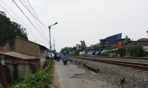 Pengendara motor melewati jalan rusak di Cimahi.