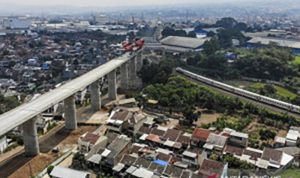 Kereta api melintas di dekat proyek konstruksi kereta api cepat Jakarta-Bandung di Lembah Teratai, Kabupaten Bandung Barat, Jawa Barat, Minggu (8/8/2021). Gubernur Jawa Barat Ridwan Kamil menyatakan uji coba kereta cepat Jakarta-Bandung ditargetkan akan dilaksanakan pada Oktober 2022 mendatang sementara pada Januari 2022, seluruh konstruksi beton proyek tersebut sudah tersambung sepenuhnya. (ANTARA FOTO/Raisan Al Farisi)