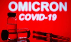 ILUSTRASI: Jarum suntik medis dan dua botol terlihat di depan teks Omicron COVID-19 di latar belakang. ANTARA/Pavlo Gonchar / SOPA Images via Reuters/Sipa USA/pri. (Pavlo Gonchar / SOPA Images/Sipa/SOPA Images)