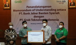 Richard Aditya, Director of West Indonesia, Grab Indonesia (kedua kanan) bersama Yose Tireza Arizal, Region Head of West Java & Central Java, Grab Indonesia (kanan pertama) saat menyerahkan bukti Penandatangan Nota Kesepahaman kepada Indra Falatehan, Direktur Utama Bank BJB Syariah (kiri kedua) yang didampingi oleh Vicky Fitriadi, Direktur Operasional Bank BJB Syariah (kiri pertama)