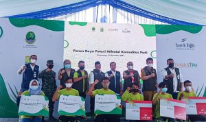 Jajaran Direksi bank bjb bersama petani milenial memperlihatkan hasil panen raya padi.