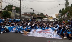 Ribuan buruh menggelar aksi duduk di Jalan Raya Cipanas-Cianjur, Jawa Barat, setelah dihadang petugas untuk menggelar aksi didepan Istana Cipanas, Cianjur, Jawa Barat, Selasa (23/11). ANTARA FOTO/Ahmad Fikri