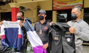 Polisi saat menunjukkan barang bukti berupa atribut anggota geng motor yang melakukan penganiayaan warga di Indramayu, Jawa Barat, Minggu (28/11/2021). (ANTARA/Khaerul Izan)