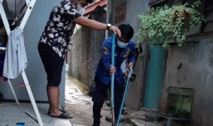 Seorang petugas DPKP Depok saat mengevakuasi seekor ular. (ist)