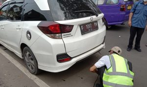 Salah satu petugas melakukan tahap uji emisi pada kendaraan. (Istimewa)