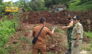 Kepala Desa Cihanjuang, Yuyus Yusuf saat meninjau area pasca longsor yang mulai dibenahi.