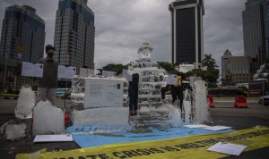 Aktivis Greenpeace Indonesia menggelar aksi di kawasan Monumen Nasional, Jakarta, Rabu (10/11/2021), untuk menyampaikan adanya ancaman besar akibat perubahan iklim. (ANTARA FOTO/Sigid Kurniawan/wsj)