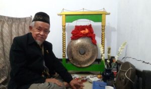 Pewaris ketujuh Gong Si Bolong, Buang Jayadi, berpose bersama Gong Si Bolong. (ANTARA/Cita Baskara)