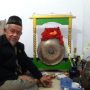 Pewaris ketujuh Gong Si Bolong, Buang Jayadi, berpose bersama Gong Si Bolong. (ANTARA/Cita Baskara)