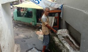 Makam Tua di Bandung Ini "Nyelip" di Antara Gang dan Menempel di Tembok Rumah Warga Dok. Sesepuh di daerah Linggawastu, Bandung, Aceng Sutisna menunjukkan ke arah makam tua yang menempel di bagian tembok rumah warga. Foto. Sandi Nugraha