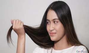 Ilustrasi wanita sedang memegang rambut. (Foto: Genpi.co)