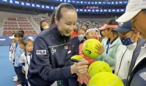 Petenis China Peng Shuai menandatangani bola tenis ukuran jumbo dalam upacara pembukaan kompetisi tenis yunior di Beijing, China, 21November2021(via REUTERS/via TWITTER @QINGQINGPARIS)