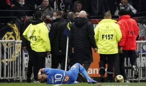 Suporter Berulah, Olympique Lyon Dijatuhi Hukum Pengurangan Poin Penyerang Marseille Dimitri Payet terkapar setelah terkena pelemparan botol plastik minuman kemasan oleh suporter tuan rumah Olympique Lyon dalam pertandingan lanjutan Liga Prancis di Stadion Groupama, Lyon, Prancis, Minggu (21/11/2021) waktu setempat. (ANTARA/REUTERS/Benoit Tessier)