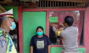 Petugas Kepolisian Resor Metro Bekasi menempel stiker warga Kabupaten Bekasi yang melakukan perjalanan mudik selama musim Lebaran 2021. ANTARA/Pradita Kurniawan Syah.