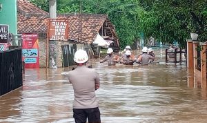 ILUSTRASI: Anggota Polres Sumedang saat melakukan evakuasi korban banjir. (ISTIMEWA)