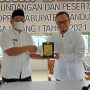 Anggota Komisi A DPRD Kabupaten Bandung Fraksi Golkar, Riki Ganesa memberikan plakat kepada Kepala Desa Cinunuk Karena telah mensukseskan Vaksin Covid-19. (Yully S Yulianty/Jabar Ekspres)