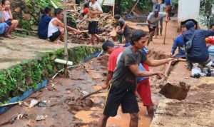 BENCANA: Warga Desa Ciherang saat gotong royong bersihkan material tanah akibat luapan air dan longsor.