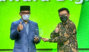 Ketua Relawan TIK Jawa Barat, M Nur Fajar Muaharam memberikan penghargaan kepada Gubernur Jawa Barat, Ridwan Kamil sebagai Jawara Digital di Saung Angklung Udjo, Selasa (21/12). (Foto: Yuga Hassani/Jabar Ekspres)