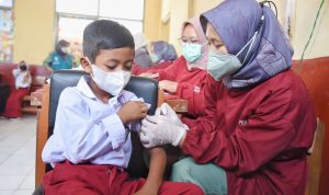 Petugas Dinkes Kabupaten Bandung sedang menyuntikan vaksin anak di Sekolah Dasar. (Istimewa)