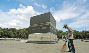 Petugas membersihkan halaman gedung yang akan digunakan untuk jemaah umrah di Asrama Haji Pondok Gede, Jakarta Timur, (1/12). (SALMAN TOYIBI/JAWA POS)