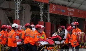 KEBAKARAN: Petugas penyelamat membawa seorang korban dari gedung World Trade Center yang terbakar di Hong Kong, Rabu (15/12/2021). ANTARA/REUTERS/Lam Yik/as.