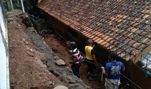 Rumah Isur, 52, warga Dusun Cibitung, RT03 RW03, Desa Sawahdadap, Kecamatan Cimanggung, Kabupaten Sumedang yang jebol tertimpa TPT mulai diperbaiki. (Jabar Ekspres)