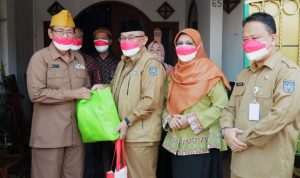 Wali Kota Depok, Mohammad Idris didampingin Supian Suri (Setda) Depok dan Bunda Elly Farida (Ketua TP-PKK Kota Depok), saat menyerahkan secara simbolis paket sembako dari program D'SabR beberapa waktu lalu, (foto: istimewa).