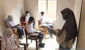 Sejumlah siswa MTs Nurul Huda di Desa Keblukan, Kaloran, Kabupatren Temanggung, Jawa Tengah, Senin (17/1/2022) belajar di rumah warga karena atap ruang kelas roboh. FOTO ANTARA/Heru Suyitno