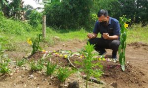 Salah seorang pelayat berdoa di depan makam siswa SD yang meninggal usai kriitis setelah divaksin di Purbaratu, Kota Tasikmalaya. Foto:Rezza Rizaldi / radartasik.com