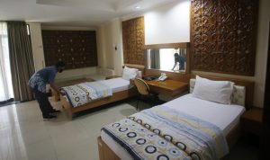 ILUSTRASI: Petugas merapikan kamar untuk jemaah umrah di Asrama Haji, Pondok Gede, Jakarta Timur, Rabu (1/12/2021). (Dery Ridwansah/ JawaPos.com)