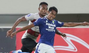 Pemain Persib Bandung, Frets Butuan (kanan) bersiap melepaskan tembakan ke gawang Madura United dalam laga Liga 1 2021-2022. (Ahmad Khusaini/Jawa Pos)
