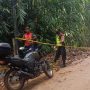 Anggota Polsek Cibugel dibantu Dishub dan relawan dalam menutup akses jalan yang terimbas longsor selama proses evakuasi. *Istimewa