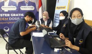 Salah seorang peserta vaksinasi booster DPD Nasdem Kota Bandung mengisi formulir sebelum dilakukan penyuntikan, di Kantor DPD Nasdem Kota Bandung, Selasa (25/1).