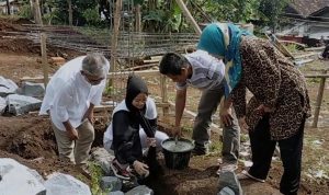 Atlet Angkat Besi asal Kabupaten Bandung, Windy Cantika, saat meletakan sebuah batu dan adukan semen pertama pada bangunan pondasi bangunan masjid, Minggu (30/1).
