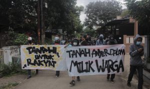 UNJUK RASA: Warga Anyer Dalam membentangkan spanduk disaat hendak geruduk kantor Kelurahan Kebon Waru, pada Senin (15/2) kemarin. (Deni/Jabar Ekspres)