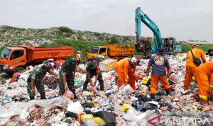 TPS liar Ditutup, Sehari 25 Truk Sampah Dipindahkan di Bekasi Prajurit TNI bahu-membahu bersama petugas Dinas Lingkungan Hidup Kabupaten Bekasi, Jawa Barat mengangkut sampah di Tempat Pembuangan Sampah liar Kali CBL Desa Sumberjaya, Kecamatan Tambun Selatan, Jumat. (ANTARA/Pradita Kurniawan Syah).